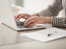 Businesswoman working on laptop, female hands typing on keyboard