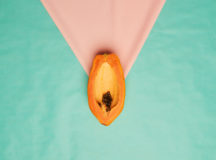 Studio shot of a papaya slice against turquoise a background